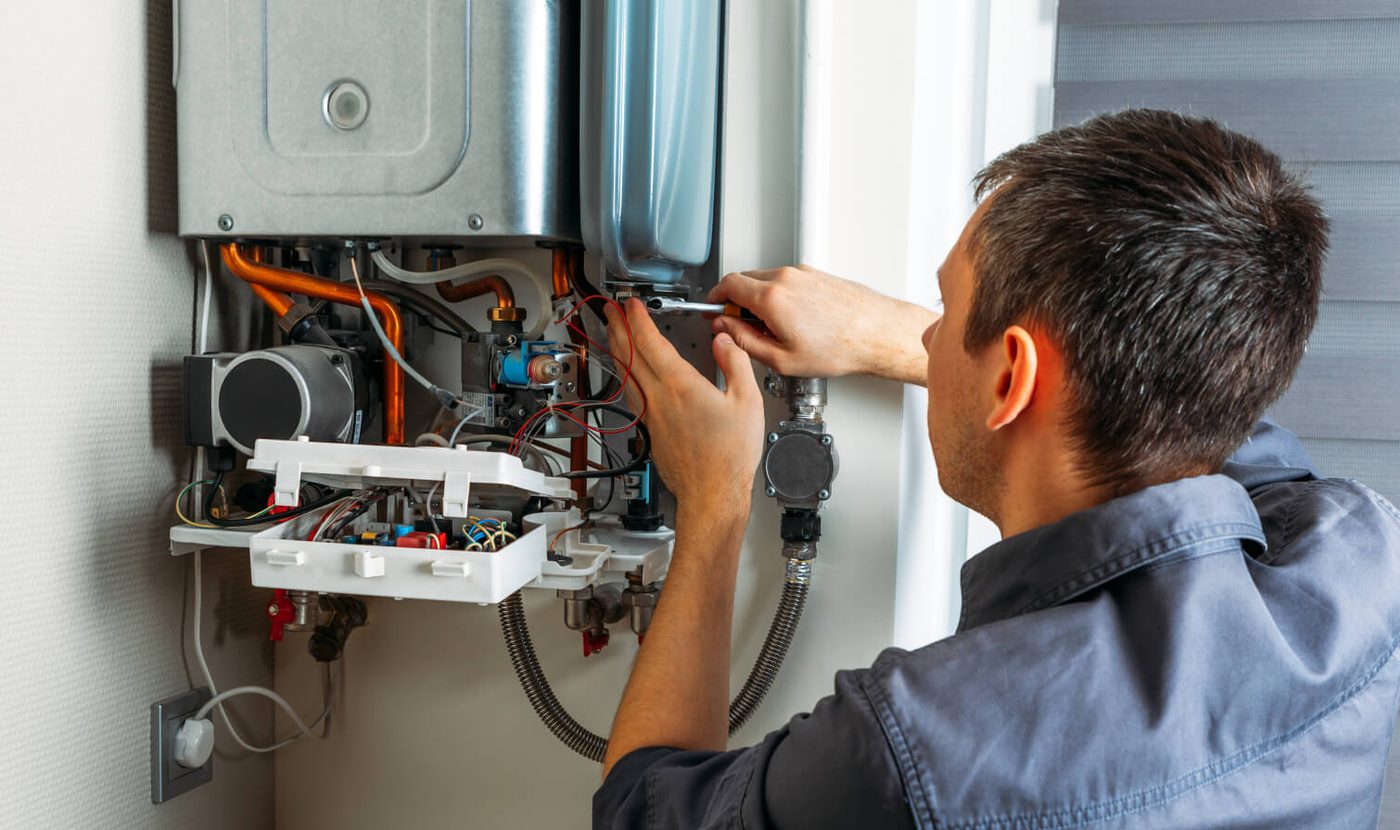 Technician repairing combi boiler